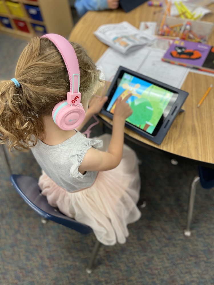 Girl on computer tablet wearing headphones