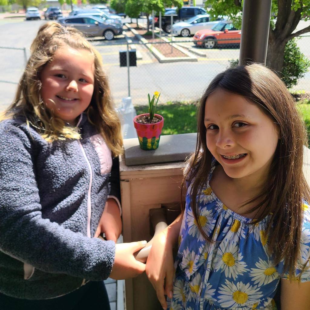 two little girls plant flowers