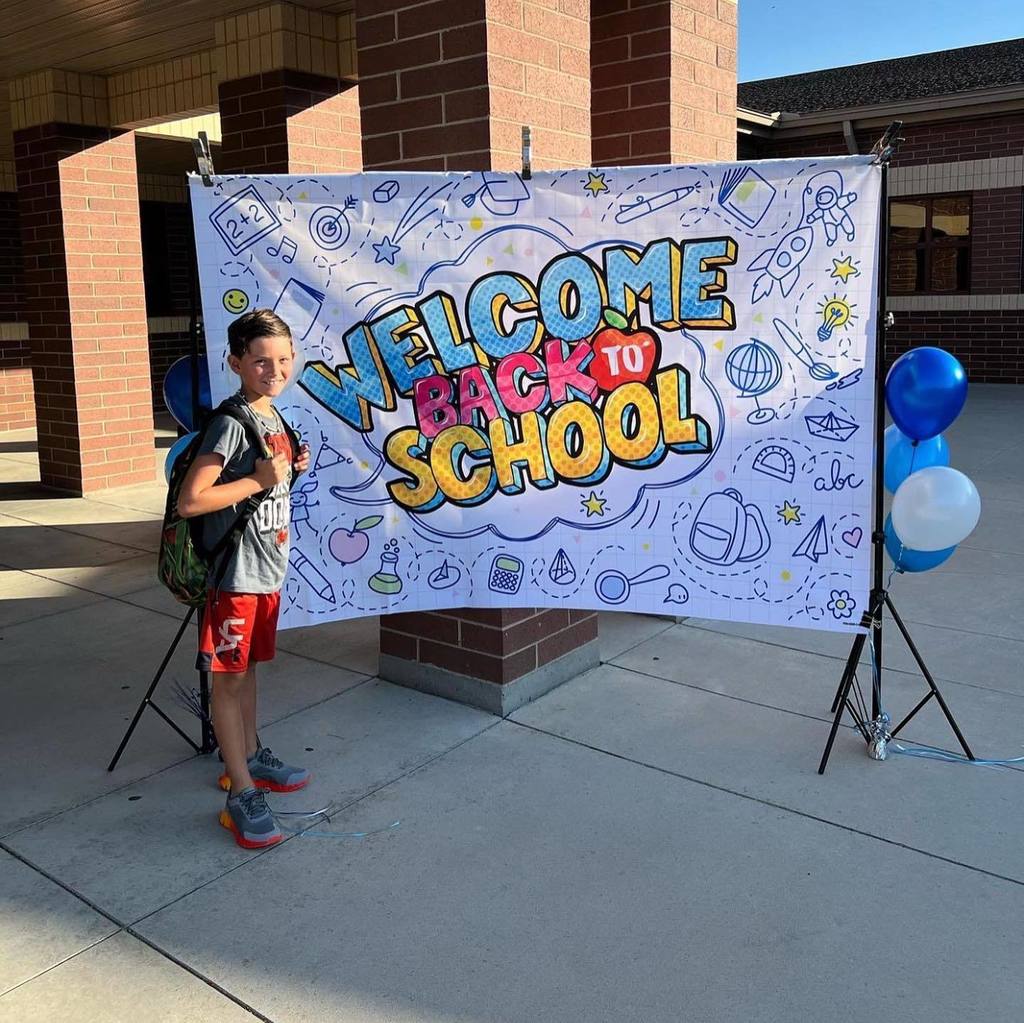 student standing in front of back to school sign